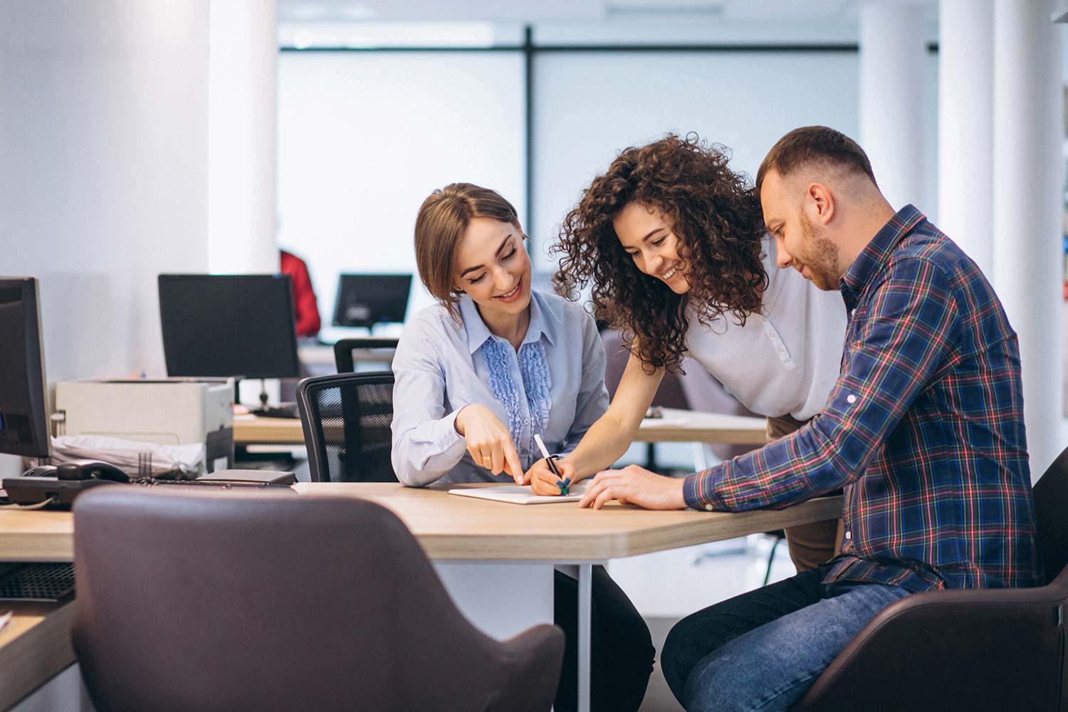 Finanzierung leicht gemacht. Pärchen bekoommt eine Finanzierung von einer Mitarbeiterin vorgerechnet.